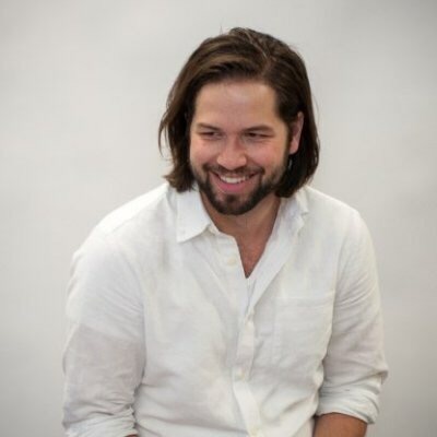 Photo of Adam in a white shirt smiling